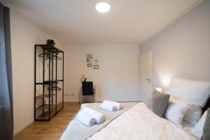 um quarto com uma cama com duas almofadas em DWELLSTAY - Premium Wohnung I 95qm I 3 Schlafzimmer I großes Bad I Küche I Wohnzimmer I TV em Fulda