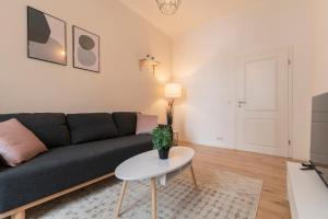 uma sala de estar com um sofá e uma mesa em DWELLSTAY - Premium Wohnung I 95qm I 3 Schlafzimmer I großes Bad I Küche I Wohnzimmer I TV em Fulda