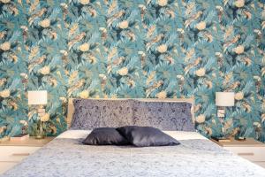 Schlafzimmer mit einem Bett mit Blumentapete in der Unterkunft Green Apartment Catania in Catania