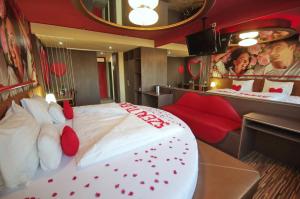 a bedroom with a large white bed with red pillows at Hotel Corvin in Gyula