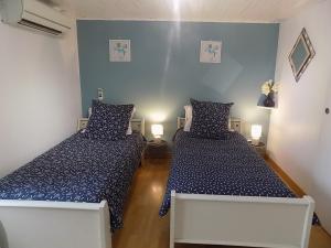 2 camas en una habitación con paredes azules en gite le peuplier, en Boisset