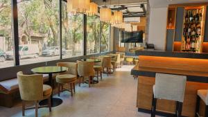 un restaurante con mesas y sillas y un bar en Ferrol Apart Hotel en Funes