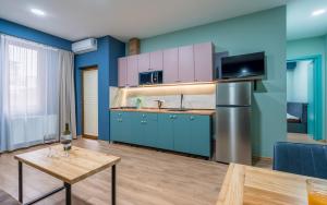 uma cozinha com armários azuis e uma mesa de madeira em Hotel City Lights - Tbilisi em Tbilisi