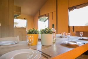 a table with plates and glasses and a bottle of wine at Little Pig Glamping in Bude