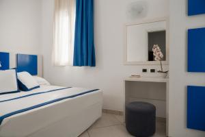 a bedroom with a bed with blue curtains and a table at Hotel Embassy in Riccione