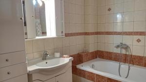 a bathroom with a tub and a sink at VILLA MALILA in Panagia