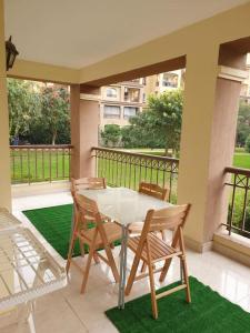 a table and chairs on a patio with a balcony at Luxury Inn 3BR Amazing Garden view in Madinaty B1 in Madinaty