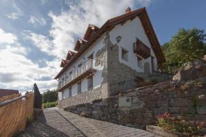 a stone building with a balcony on the side of it at Casa rural Enekoizar in Abaurrea Alta