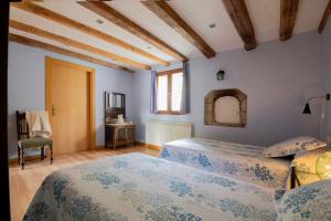 a bedroom with two beds and a table and a chair at Casa rural Enekoizar in Abaurrea Alta