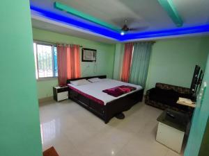 a bedroom with a bed with blue lights on it at Hotel Geetanjali Palace in Kalyani