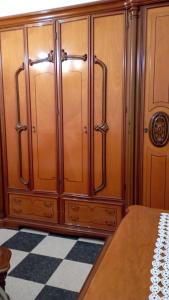 une armoire en bois dans une chambre avec un sol en damier dans l'établissement Casa Mia Russotto 3 Sicilia, à Niscemi