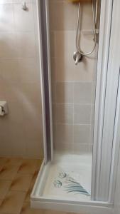 La salle de bains est pourvue d'une douche avec une porte en verre. dans l'établissement Casa Mia Russotto 3 Sicilia, à Niscemi