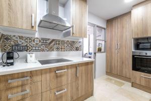 kuchnia z drewnianymi szafkami i zlewem w obiekcie Apartament Claro w mieście Torrevieja