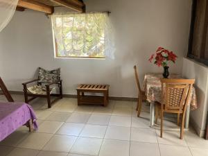 Pokój ze stołem, krzesłami i oknem w obiekcie Maison bord de mer w mieście Mangalimaso
