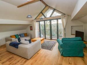 a living room with a couch and two chairs at Green Grove Barn in Carmarthen