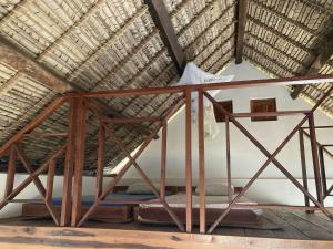 łóżko w pokoju z dachem krytym strzechą w obiekcie Maison bord de mer w mieście Mangalimaso