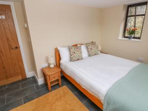 a small bedroom with a bed and a window at Green Grove Barn in Carmarthen