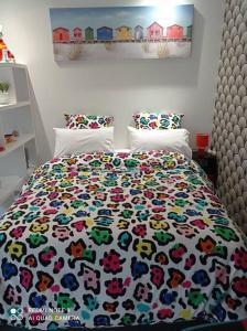 a bedroom with a bed with a floral bedspread at L'arc-en-ciel in Le Tréport