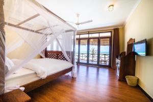 a bedroom with a bed with a mosquito net at Mahi Mahi Beach Hotel in Jambiani