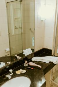 a bathroom with a sink and a mirror at Vitoria Praia Hotel in Vitória