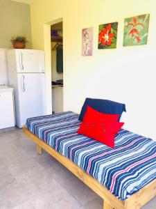 Un dormitorio con una cama con almohadas rojas. en Casa de Marga en Tandil