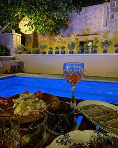 a table with food and a wine glass next to a swimming pool at Sclopa The Laography Project in Kolymvari
