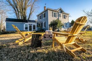 - deux chaises en bois assises devant une maison dans l'établissement Dog and Family Friendly 4BR w WIFI and Fenced Yard By Zen Living Short Term Rental, à Luray