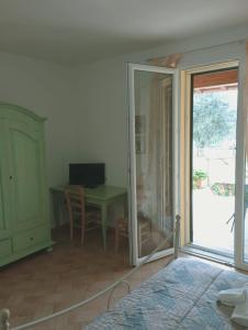 フォッローニカにあるAgriturismo dal Pastoreのデスク、ガラスドア付きのテーブルが備わる客室です。