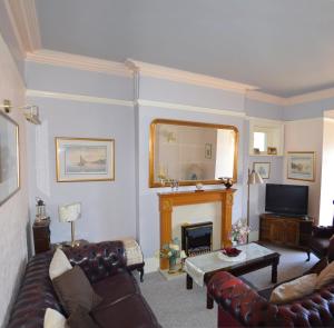 a living room with a couch and a fireplace at Hayes Barton in Shanklin