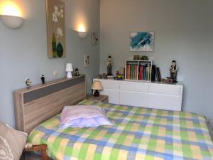 ein Schlafzimmer mit einem Bett und einem Regal mit Büchern in der Unterkunft LE RENDEZ VOUS DES VACANCES in Fouras