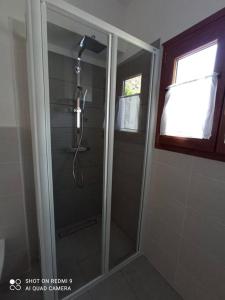 La salle de bains est pourvue d'une douche avec une porte en verre. dans l'établissement Millefiori house, à Antronapiana