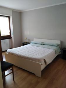 - une chambre avec un grand lit blanc et une fenêtre dans l'établissement Millefiori house, à Antronapiana