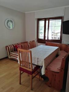 - une salle à manger avec une table, des chaises et un canapé dans l'établissement Millefiori house, à Antronapiana