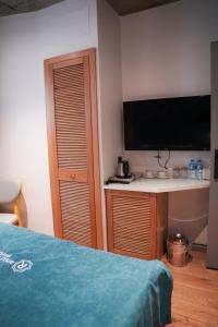 1 dormitorio con 1 cama y escritorio con TV en Royal Galata Hotel en Estambul