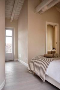 a bedroom with a bed with a striped blanket at CASA OTTO @ BELVEDERE PANORAMIC VIEW POINT in La Morra