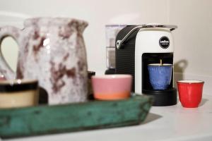 eine Kaffeemaschine und Tassen auf einer Theke in der Unterkunft CASA OTTO @ BELVEDERE PANORAMIC VIEW POINT in La Morra
