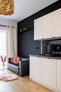 kuchnia z białymi szafkami i kanapą w obiekcie Wyjątkowy apartament z prysznicem pośrodku na wyjątkowe wieczory w Łodzi