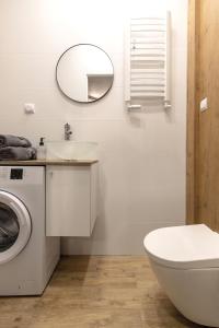 łazienka z umywalką, toaletą i lustrem w obiekcie Wyjątkowy apartament z prysznicem pośrodku na wyjątkowe wieczory w Łodzi
