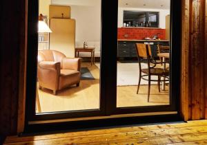 a view of a living room with a chair and a kitchen at Holzhaus mit Kamin - Am Forellenfluss 