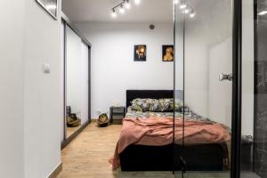sypialnia z łóżkiem i lustrem w obiekcie Wyjątkowy apartament z prysznicem pośrodku na wyjątkowe wieczory w Łodzi