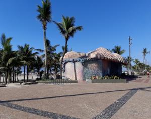 a building with palm trees on a street at Kit Relu in Praia Grande