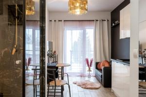 kuchnia i salon ze stołem i krzesłami w obiekcie Wyjątkowy apartament z prysznicem pośrodku na wyjątkowe wieczory w Łodzi