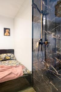 una ducha con puerta de cristal en un dormitorio en Wyjątkowy apartament z prysznicem pośrodku na wyjątkowe wieczory NAD JASIENIEM 39 Łódź, en Łódź