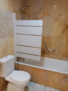 a bathroom with a toilet and a bath tub at Hotel Trafalgar in Jerez de la Frontera