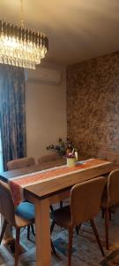 a dining room with a large wooden table and chairs at Monica City Apartament in Timişoara