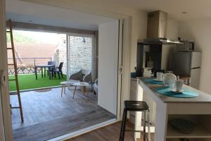 cocina con puerta corredera que conduce a un patio en Gîte L'armu avec Spa Privé en Savas