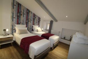Habitación de hotel con 2 camas y sofá en La Maison Vieille avec Spa Privé, en Savas