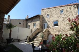 a stone house with a staircase in a yard at La Maison Vieille avec Spa Privé in Savas