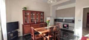 kuchnia z drewnianym stołem z krzesłami i lodówką w obiekcie La Casa di Amelie w mieście Parma