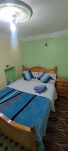 1 Schlafzimmer mit 2 Betten und blauen Kissen in der Unterkunft Casa Lotfi 1 in Chefchaouen